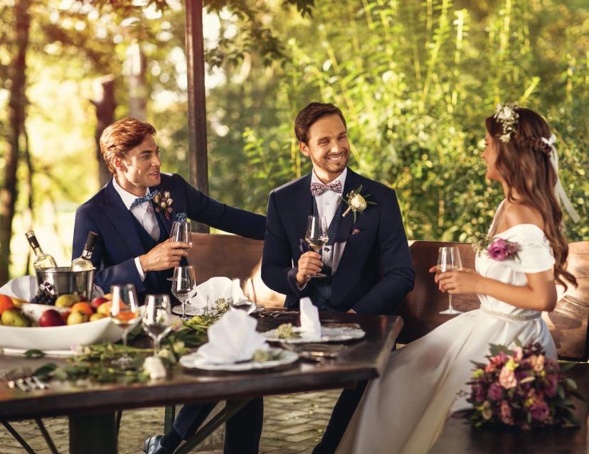 3 persons in ceremony outfits discussing around a table
