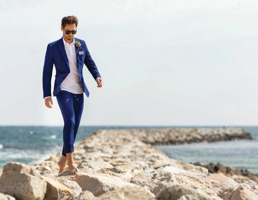 Man in blue suit and white shirt by the sea